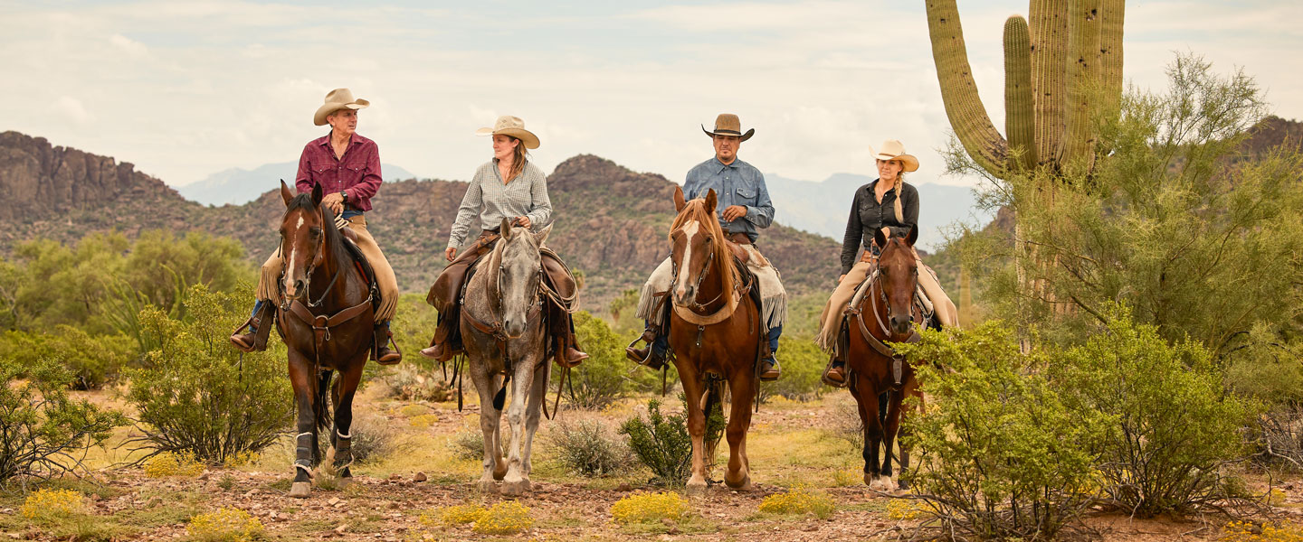 Un grupo de personas a caballo en el desierto.